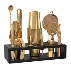 a black and gold shelf with various golden items on it's sides, including utensils and spoons