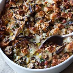 a casserole dish with meat and vegetables in it is being eaten by a spoon