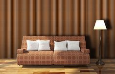 a living room with a couch, lamp and wallpaper on the walls in brown tones