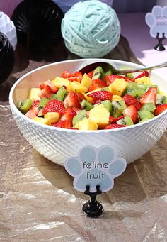 a white bowl filled with fruit sitting on top of a table