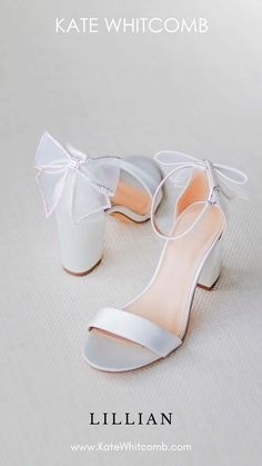 a pair of white shoes with bows on them