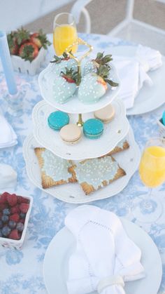 a table topped with plates and cups filled with desserts on top of each other