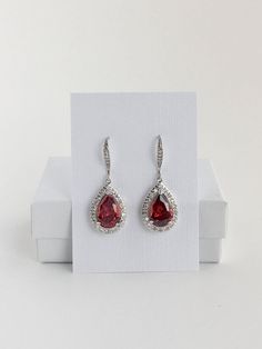 I've created these gorgeous red ruby cubic zirconia bridal tear drop dangle earrings in rhodium plated brass setting. Earrings feature a large teardrop with pear cut red ruby cubic zirconia center surrounded by tiny round zirconia crystals. Teardrop dangles from a cubic zirconia detailed ear wire. Total length of the earring is 3.8 cms. For matching necklace click: https://www.etsy.com/listing/469844682/red-ruby-cubic-zirconia-teardrop-bridal?ref=shop_home_active_26 For matching bracelet click: Red Wedding Jewelry, Red Crystal Jewelry, Crystal Wedding Necklace, Dressy Earrings, Red Bridesmaid, Blue Sapphire Bracelet, Teardrop Jewelry, Long Pearl Earrings, Crystal Earrings Wedding