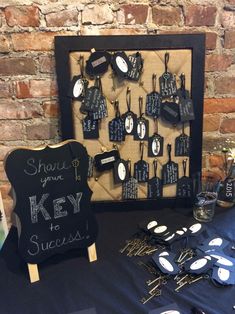 a table topped with lots of black and white magnets next to a sign that says share your key to success