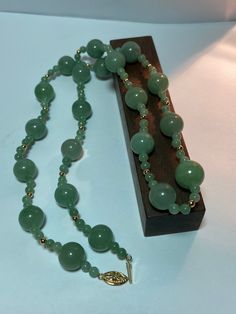 This is a beautiful, vintage, natural, genuine 14K yellow gold, green jade and 14K gold beads necklace. The necklace is about 25 1/2 inches.  The necklace is so unique and features large, natural, round green jade that is 13mm (about 1/2" in diameter) then there are 2 smaller, natural, round green jade that are 5mm (about 3/16" in diameter) separated with a 14K yellow gold bead that is about 1/8" in diameter. So there are 4 smaller green jade balls and 1 14K yellow gold bead between each of the larger green jade balls. The high-quality jade is a gorgeous green color. Just stunning and very well-made. The necklace has a secure 14K slide clasp that is ornate with a flower on it. The necklace weighs an impressive 58.2 grams. It is marked 14K WW. I am unsure who the artisan is who uses that ha Gold Beads Necklace, Vintage Navajo Jewelry, Green Jade Necklace, Jade Bead Necklace, Diamond Gold Ring, Real Gold Jewelry, Navajo Jewelry, Gold Bead Necklace, Earrings Turquoise