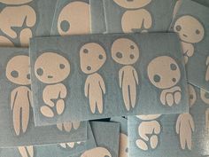 several stickers with faces and hands on them are arranged in a pattern that appears to be alien