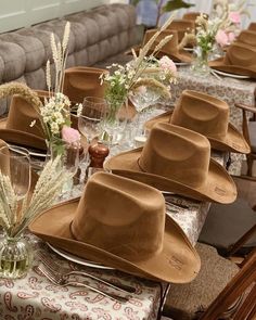 a table topped with lots of brown hats on top of it's tables covered in place mats