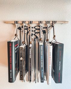 an assortment of baseball bats hanging from a rack on the wall above a bat holder