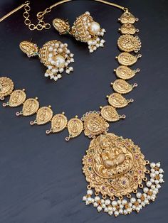 Traditional yet trendy gold finished necklace set featuring Goddess Lakshmi with matching peacock jhumkas for special occasions such as Anniversary, Engagement, Party, Wedding or for gifting . Measurements of the earrings: Height : 4.5 Cm  Width : 2.2 Cm  Product care: Avoid contact with Chemicals such as Perfumes or any Sprays. Prevent the Jewellery from the water. Use Butter Paper or Cotton Cloth to store your Jewellery for a longer Product life. Luxury Temple Jewelry For Gift, Luxury Temple Jewelry Danglers For Festive Occasions, Luxury Temple Jewelry Danglers For Celebrations, Lakshmi Temple, Kemp Necklace, Butter Paper, Temple Jewelry, Gold Jewelry Simple Necklace, Indian Necklace