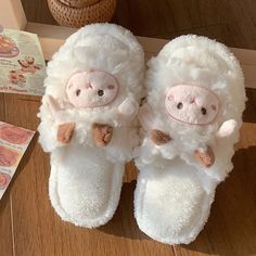 two white sheep slippers sitting on top of a wooden floor