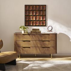 a brown chair sitting next to a wooden dresser with a clock on top of it