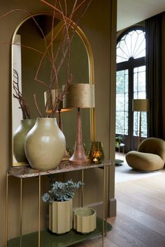 a living room filled with lots of furniture and vases on top of a shelf