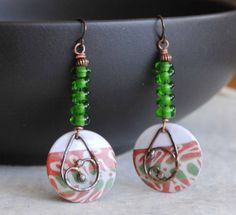 A different twist to your usual holiday earrings featuring green and reddish coral enamel charms. The abstract pattern on the enamels reminds me of a tree branch. I have paired them with spiraling green lampwork beads and copper beads. I have accented them with teardrop shaped copper components. These unique earrings measure 2 1/2 inches in total length and hang on niobium earring hooks. All pieces come boxed ready for gift giving or keeping for yourself. Return to shop: bstrung.etsy.com More li Green Beaded Earrings For Festive Occasions, Bohemian Green Jewelry For Holiday, Green Wire Wrapped Beaded Earrings For Gift, Green Wire Wrapped Beaded Earrings As Gift, Festive Green Nickel-free Earrings, Green Spiral Earrings As Gift, Blue And White Earrings, Lampwork Bead Earrings, Bohemian Christmas