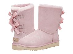 UGG Bailey Bow II Shimmer - Women's Shoes : Pink Cloud : Keep warm and look good in the UGG Bailey Bow II Shimmer mid-calf boot; crafted from a metallic suede upper topped with a satin bows at back for added appeal. Features a round toe and polyester bindings. Offers 17mm of cozy UGGplush made from 80% wool and 20% lyocell. New Treadlite by UGG outsole provides increased traction, durability, cushioning and flexibility. Imported. Measurements: Heel Height: 1 1 4 in Circumference: 14 in Shaft: 6 Womens Pink Uggs, Pink Uggs With Bows, Feminine Esthetics, Bow Uggs, Expensive Outfits, Cute Uggs, Uggs With Bows, Ugg Bailey Bow, Uggs Boots