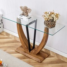 a glass table with an elephant figurine on top and some flowers in a vase