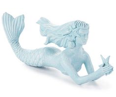 a blue mermaid figurine sitting on top of a white surface