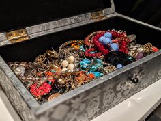 an open trunk filled with lots of different types of necklaces and brooches