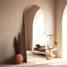 an arch shaped mirror in a room next to a table with a potted plant on it