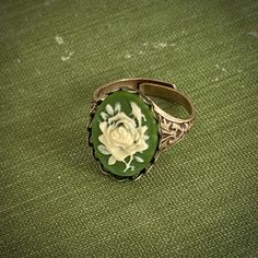 18x13mm green and white acrylic flower cameo. Available on an antiqued brass or silver adjustable victorian cigar band ring. Easy to adjust to most sizes.Cameo available in single rose or bouquet design. Green Vintage Adjustable Rings, Adjustable Vintage Green Rings, Vintage Green Flower Ring, Vintage Adjustable White Flower Ring, Locket Ring, Acrylic Flower, Aesthetic Jewelry, Cameo Jewelry, Single Rose