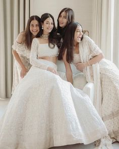 three women in white dresses posing for the camera