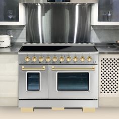 a kitchen with two ovens and a stove in the middle of the counter top