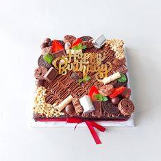 a birthday cake decorated with chocolate, marshmallows, strawberries and candy