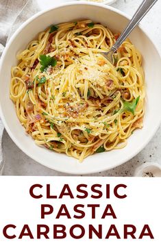 a white bowl filled with pasta and topped with parmesan cheese next to a fork