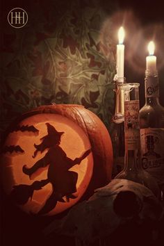 a pumpkin carved to look like a witch next to some liquor bottles and a candle