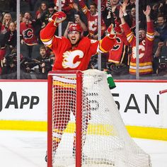 the hockey player is celebrating his team's victory over the crowd in front of him