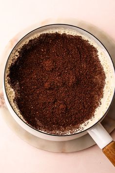 a pan filled with food sitting on top of a white counter next to a wooden spatula