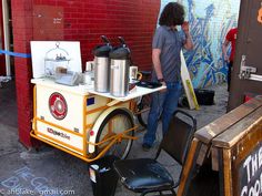 a man standing next to a bike with an ice cream cart on it