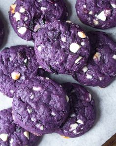 purple cookies with white sprinkles are on a baking sheet and ready to be eaten