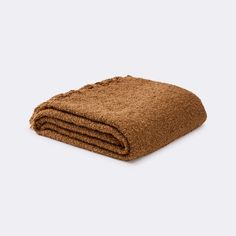 a brown blanket folded on top of a white surface