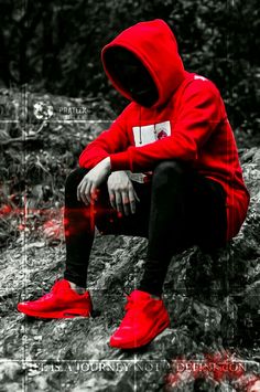 a person in a red hoodie and black pants sitting on a rock with their feet up