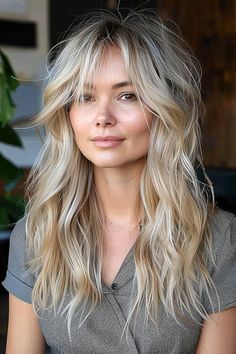 A woman with an effortless blonde long shag hairstyle and natural volume. Long Blond Shaggy Hair, Long Shag With No Bangs, Voluminous Shag Haircut, Long Shag Haircut Straight Hair No Bangs, Wolfcut Hair Medium Blonde, Shag Hairstyles Medium Blonde, Long Shag With Curtain Fringe, Faux Shag Haircut, Women’s Long Hair Shag