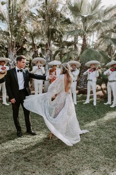 a bride and groom are dancing in front of the marching band at their wedding reception