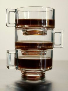 three glasses filled with liquid sitting on top of a table