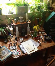 a wooden table topped with lots of different types of plants and books on top of it