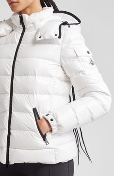 Whether you're headed somewhere metropolitan or mountainous, you'll stay warm in this sporty down puffer made from Moncler's water-resistant lacquered nylon. Elasticized cuffs and a detachable drawcord hood provide extra protection from the elements. Two-way front-zip closure Stand collar; removable drawcord hood Elastic cuffs with adjustable snap tab Front zip pockets; sleeve snap-flap pocket Lined, with down fill 100% polyamide Dry clean or machine wash, line dry Imported Designer Clothing White Sporty Quilted Outerwear, Sporty White Quilted Outerwear, White Nylon Puffer Jacket With Detachable Hood, White Down Outerwear With Padded Collar, White Nylon Puffer Jacket With Padded Collar, White Sporty Puffer Jacket With Padded Collar, Functional White Puffer Jacket With Detachable Hood, White Duck Down Outerwear For Outdoor, White Duck Down Puffer Jacket With Padded Collar