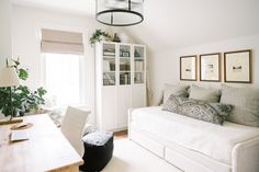 a living room filled with furniture and a white couch in front of a large window