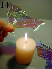 a hand holding a lit candle in front of a butterfly