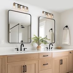 a bathroom with double sinks and two mirrors on the wall next to eachother