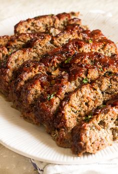 meatloaf on a plate with sauce and herbs