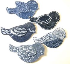 four birds made out of jeans sitting on top of a table