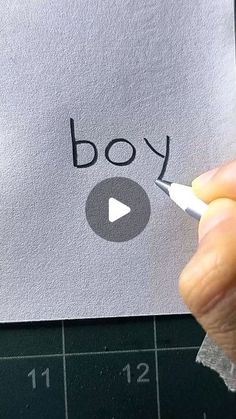 someone is writing the word boy on a piece of paper