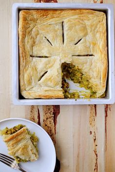 a white plate with a piece of pie on it next to a fork and knife