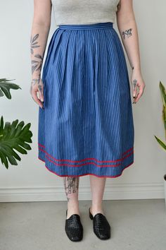 Vintage Blue Striped Pleated Skirt. Red Contrast Trim. Zipper & Button Closure in Back. Lined. 100% Cotton Lining 100% Viscose No Size Tag Excellent Vintage Condition All Measurements Taken Flat Waist-12.5" Hips-27" Length-28" All Sales Are Final. We have taken the time to note all size measurements and the condition of each piece so please look over all the information of the garment you are considering purchasing. Please note that all items are sold in "Vintage Condition". If you have any furt Retro High-waist Blue Skirt, Retro High Waist Blue Skirt, Blue Buttoned Skirt, Retro Blue Skirt With Pockets, Retro Blue Knee-length Skirt, Blue Midi Skirt For Daywear, Retro Blue Lined Skirt Bottoms, Blue Bottoms With Button Closure For Daywear, Blue Buttoned Skirt For Spring