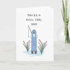 a card with an illustration of a man holding a fishing rod and saying, you're a reel cool dad