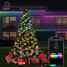 a lit christmas tree next to a smart phone with an image of a house in the background