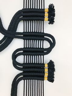 two black and yellow wires connected to each other on a white surface with no one around them